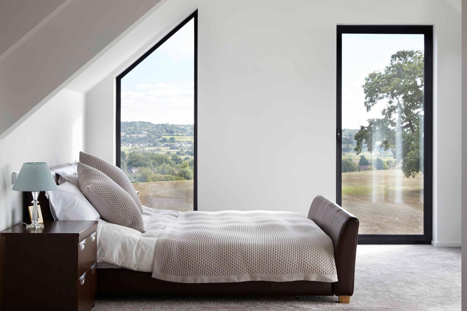 Floor-to-ceiling bedroom windows looking over countryside